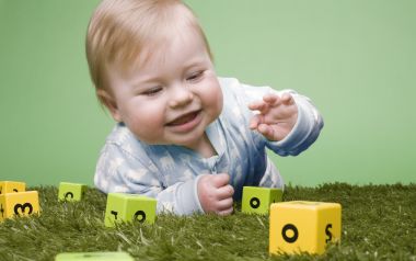 Cute Baby Playing With Alphabet Blocks On Lawn Photo