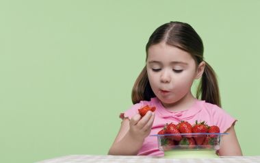 Little Girl With Pigtails Eating Fresh Strawberries