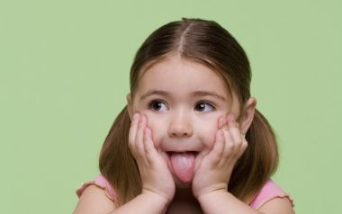 Cute Little Girl With Pigtails Sticking Tongue Out Portrait