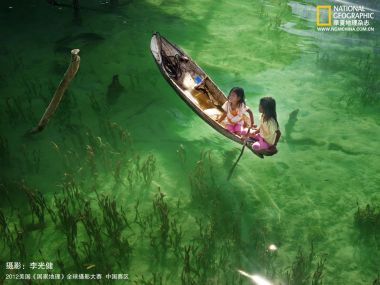 国家地理获奖摄影 碧绿澄澈浅海中小木船上的两名孩童