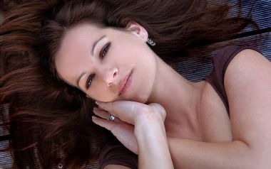 Gentle Portrait Of Brown Haired Young Woman Lying Down