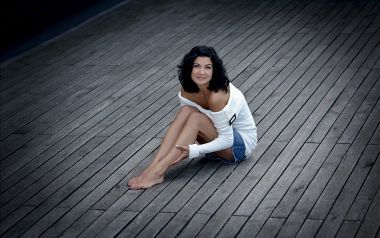 Elegant Short Haired Woman Sitting On Wooden Terrace Portrait