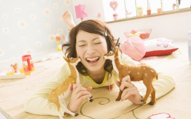 日系清新居家少女手持小鹿玩偶开怀大笑
