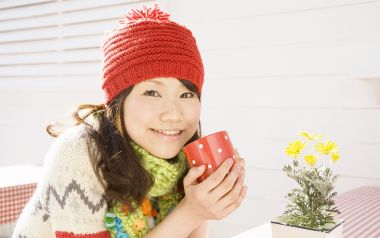 戴红色针织帽的年轻女生手持热饮温馨居家写真