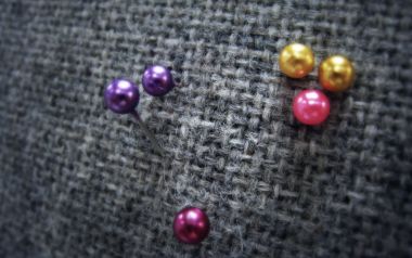 Colorful Sewing Pins On Gray Woven Fabric Macro Closeup