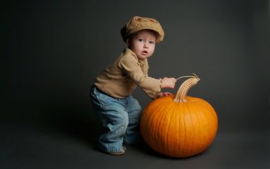 Cute Toddler Boy With Big Pumpkin Studio Portrait