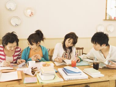 Four Young Friends Study Together At Wooden Desk Japanese Style