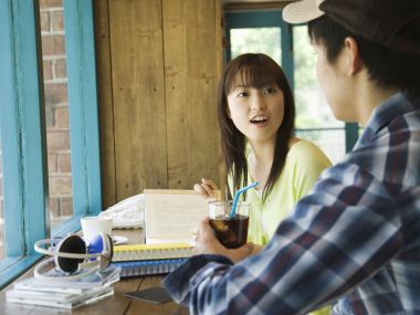 Young Couple Chatting At Japanese Cafe Window Seat