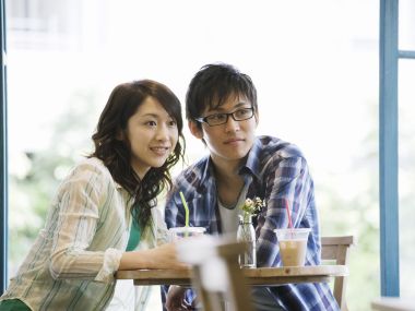 Young Japanese Couple Dating At Cafe Near Window