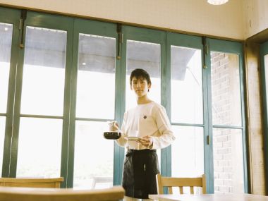 日系咖啡馆男店员端送手冲咖啡暖调写真