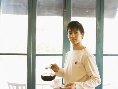 日系咖啡馆窗边端咖啡的年轻男生人像写真