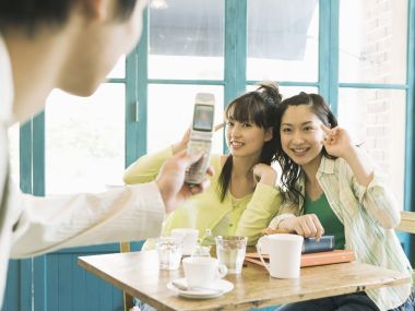 日本咖啡馆内好友用复古翻盖手机合影的青春日常