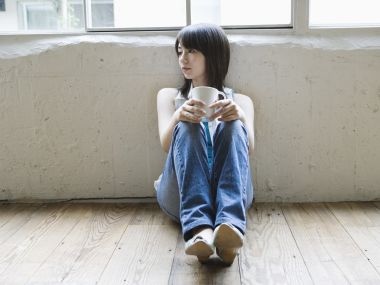 Relaxed Japanese Girl Sitting By Window Holding Mug Home Portrait