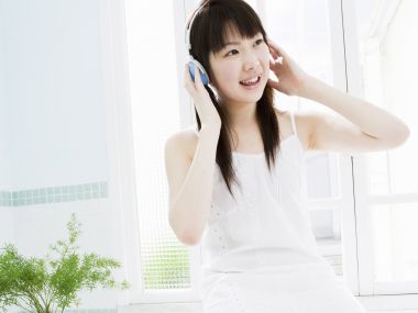 Fresh Japanese Teen Girl Listening To Music By Bright Window