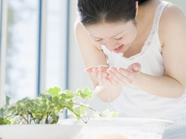 Asian Woman Washing Face By Window Morning Skincare