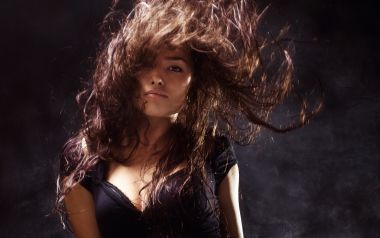 Dynamic Fashion Portrait Of Woman With Flying Curly Hair