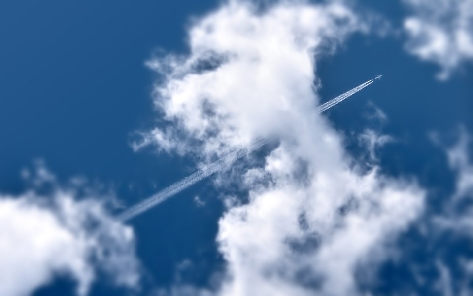 Airplane Contrail In Blue Sky With Clouds