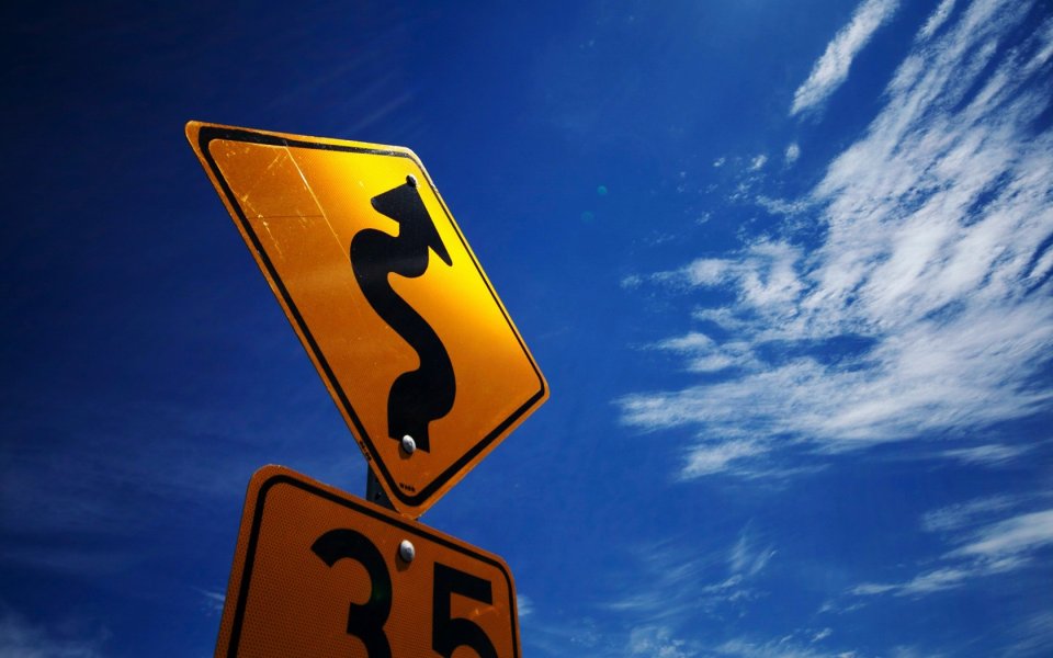 Blue Sky Curvy Road Sign And 35 Speed Limit Sign