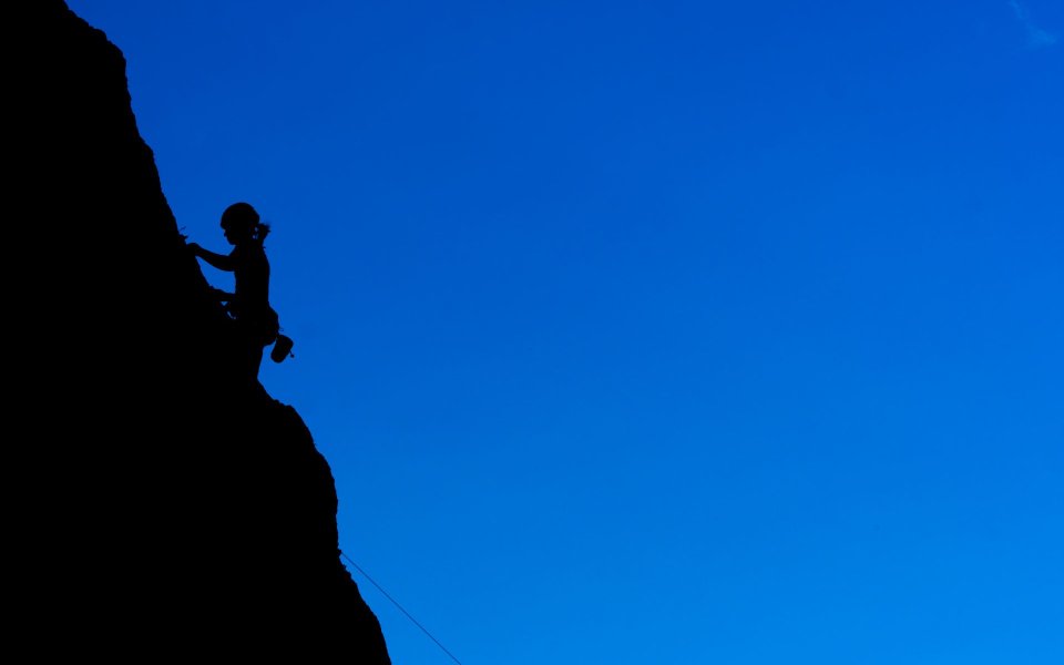 Climber Silhouette Against Blue Sky