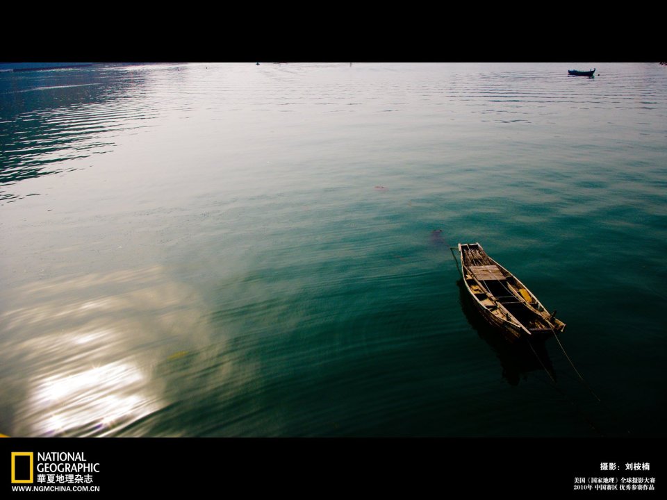 National Geographic 2010 Photo Contest Work: Serene Lake Surface With Small Boat And Sun Reflection