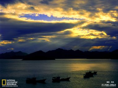 中国海面夕阳下的船只与山脉