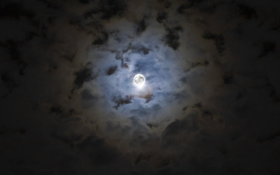 云层中透出的皎洁满月夜景