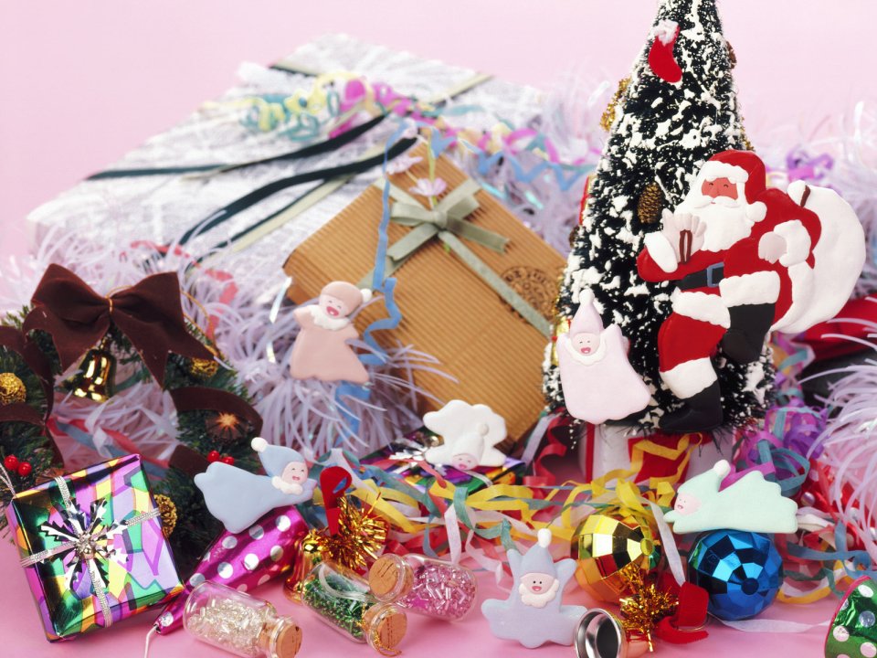Close Up Of Christmas Gifts And Santa Claus Doll On Pink Background