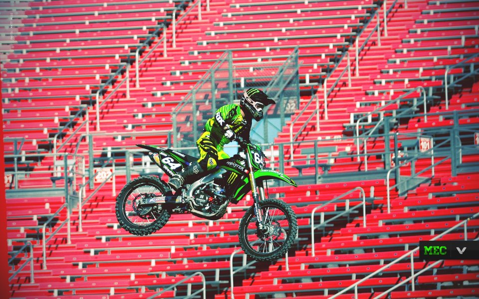 Motocross Rider Jumping In Front Of Red Stands