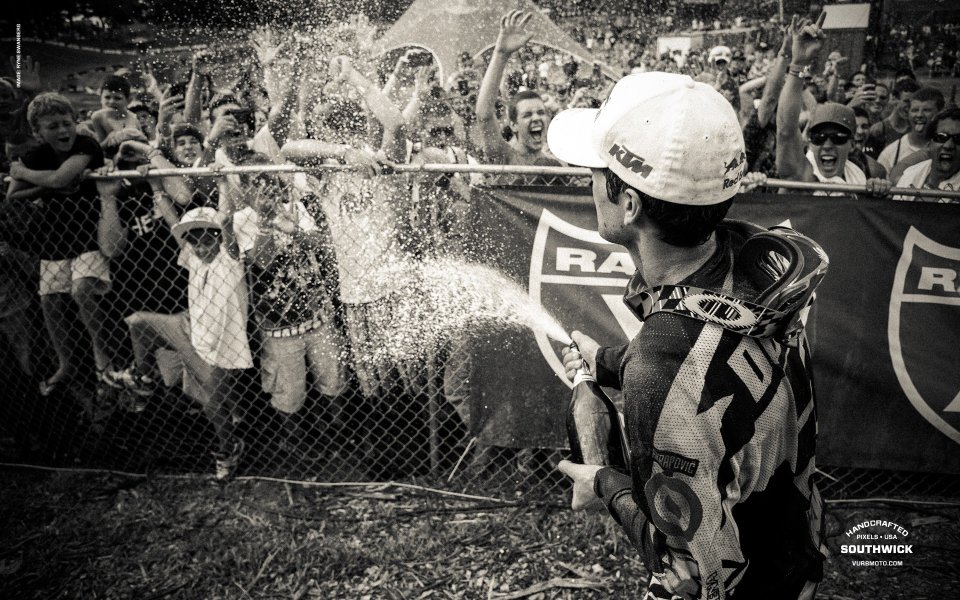 Motorcycle Rider Celebrating Victory Spraying Champagne To Audience