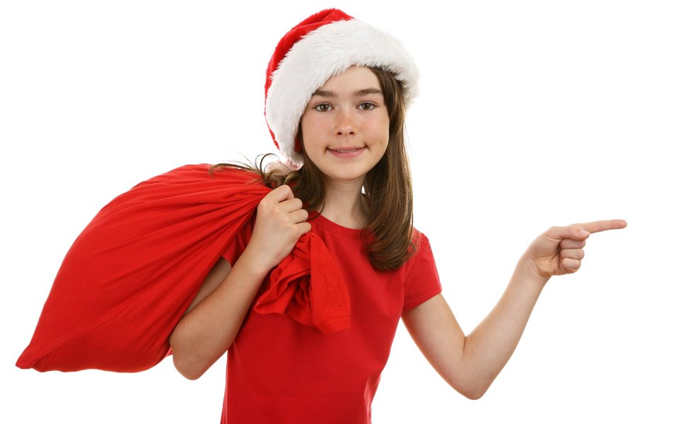 Cute Girl In Santa Hat Holding Red Sack Pointing