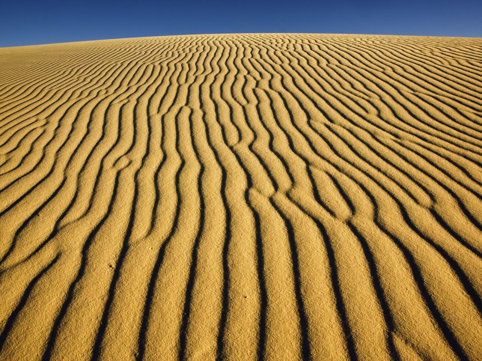 Desert Sand Dune Ripple Shadows Under Clear Blue Sky