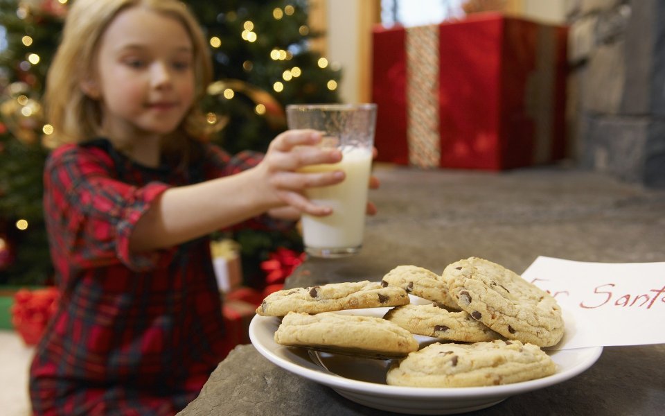 Little Girl Preparing Milk And Cookies For Santa Christmas