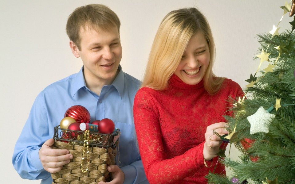 Couple Decorating Christmas Tree Indoors