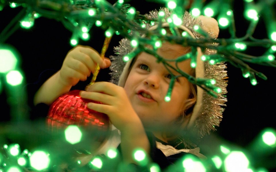Child Decorating Red Ornament Green Christmas Lights