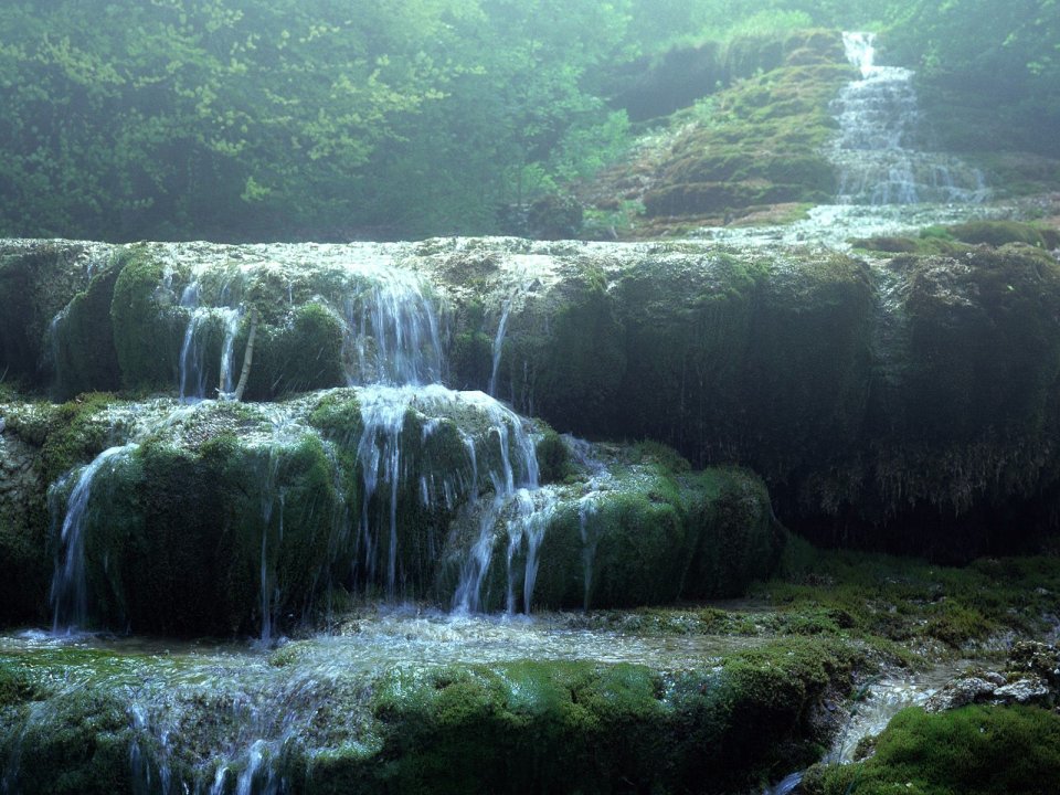 雾霭森林中层叠苔藓瀑布自然景观