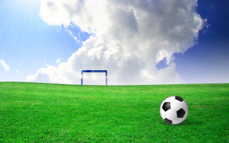 Soccer Ball On Green Football Field Under Sunny Blue Sky