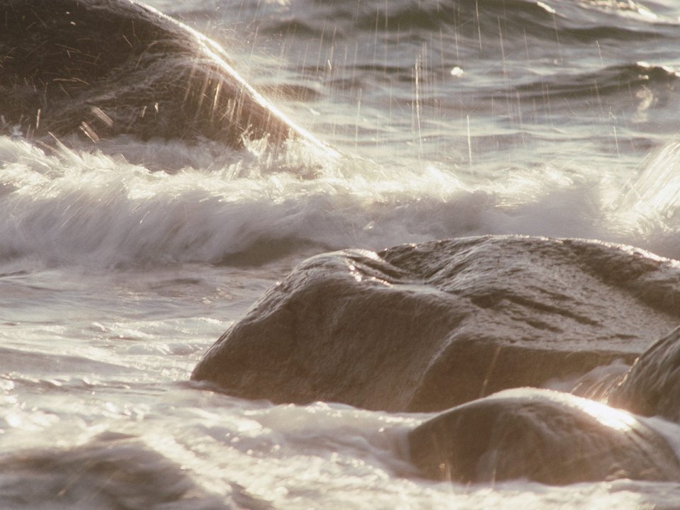 Sunlit Rocky Beach Waves Splashing On Rocks