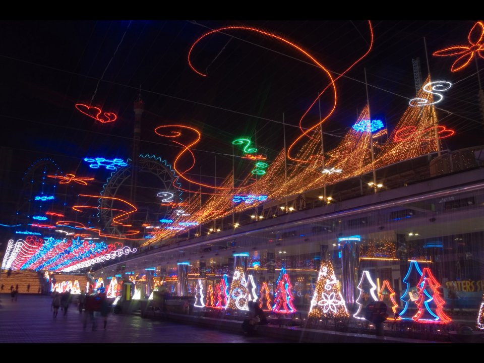 繁华都市圣诞夜景：璀璨灯光与光轨交织的节日庆典