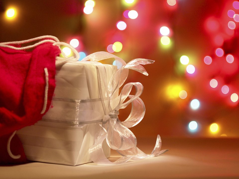 White Christmas Gift Box With Red Sock And Bokeh Lights