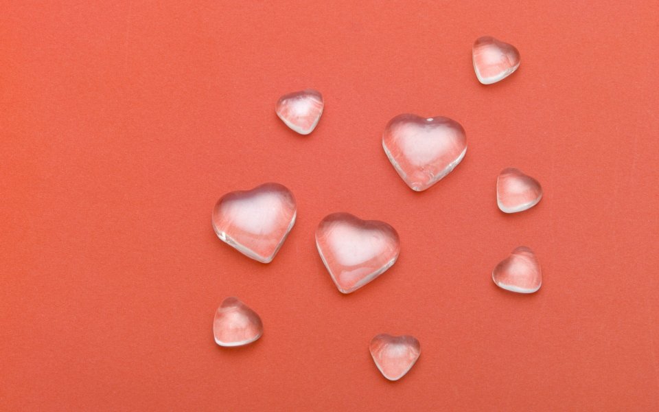Transparent Glass Hearts On Red Background