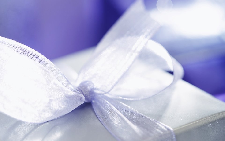White Gift Box With Ribbon Purple Background