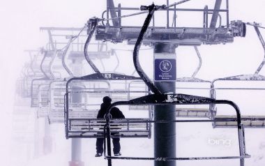 雾雪天气滑雪场单人乘坐滑雪缆车雪景