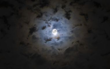 云层中透出的皎洁满月夜景