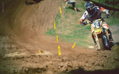 Motocross Rider Competing On Freestone Dirt Track