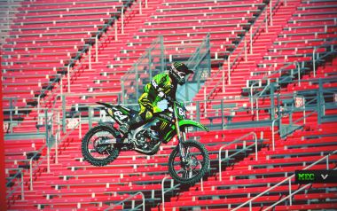 Motocross Rider Jumping In Front Of Red Stands