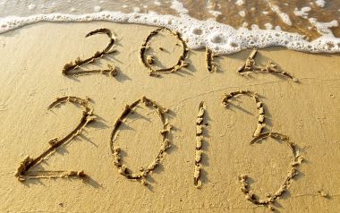沙滩上被海浪冲刷的2013与2014新年数字