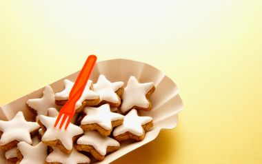 黄色背景下的星形糖霜饼干与橙色叉子特写