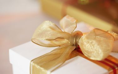 Close Up Golden Ribbon Bow On White Gift Box