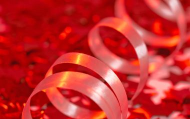 Close Up White Spiral Ribbon On Red Glitter Background