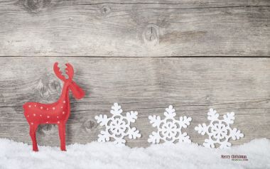 复古木质背景上的红色驯鹿与白色雪花圣诞装饰